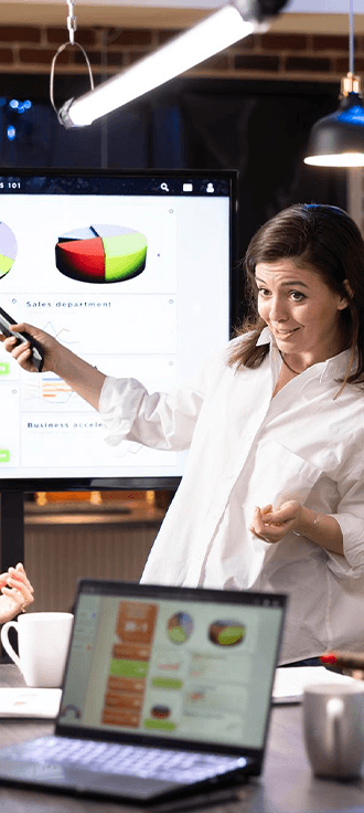 A team lead presenting charts on a screen to colleagues during a planning meeting